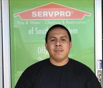 Male employee smiling with green background