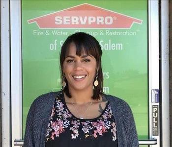 Female employee smiling with green background