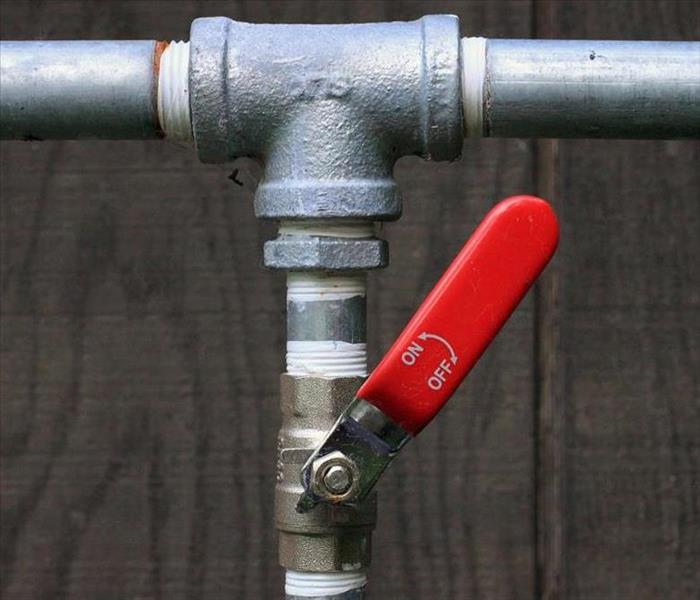 pipe with a valve with red handle 